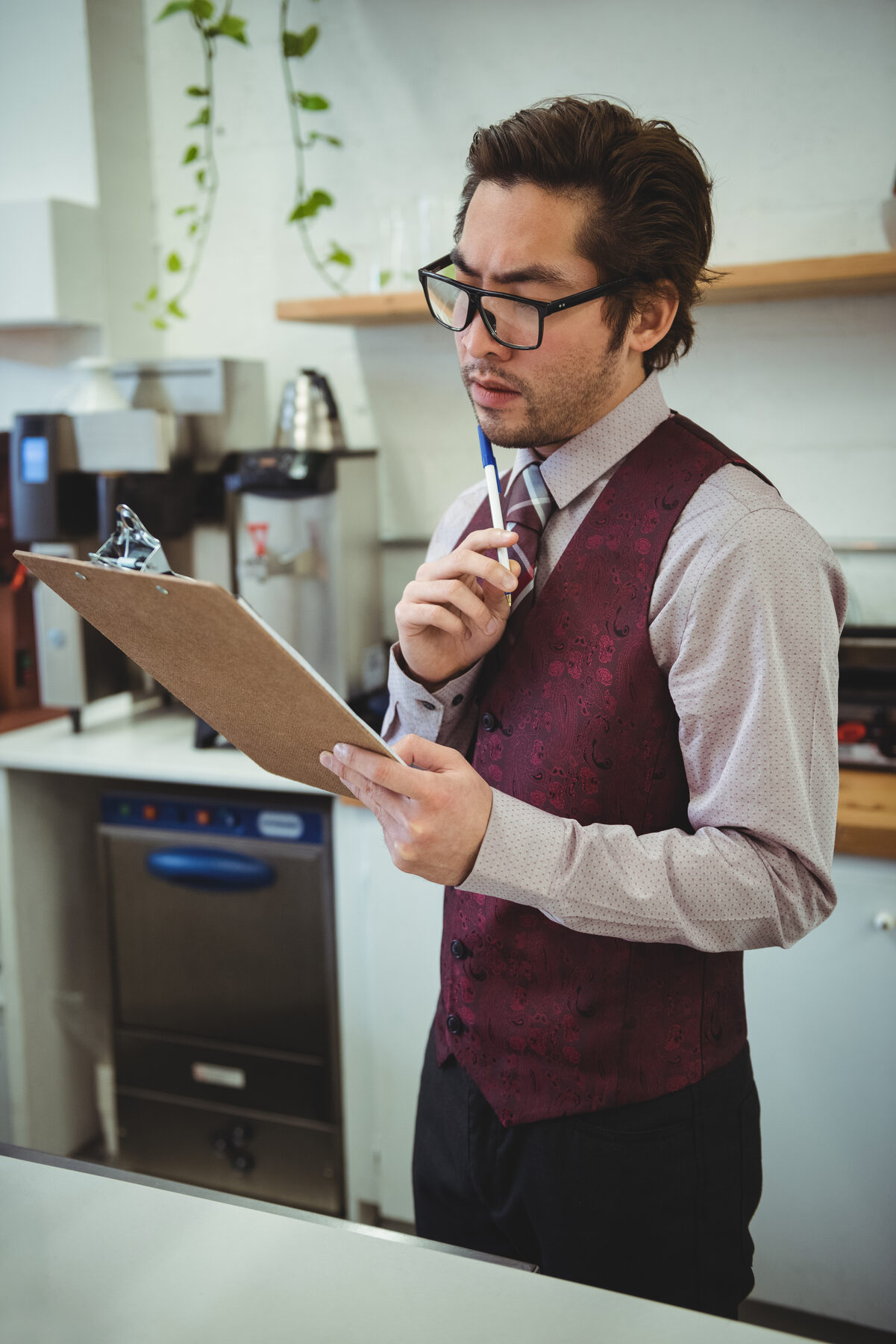 Gerente de restaurante revisando un checklist en clipboard dentro de la cocina